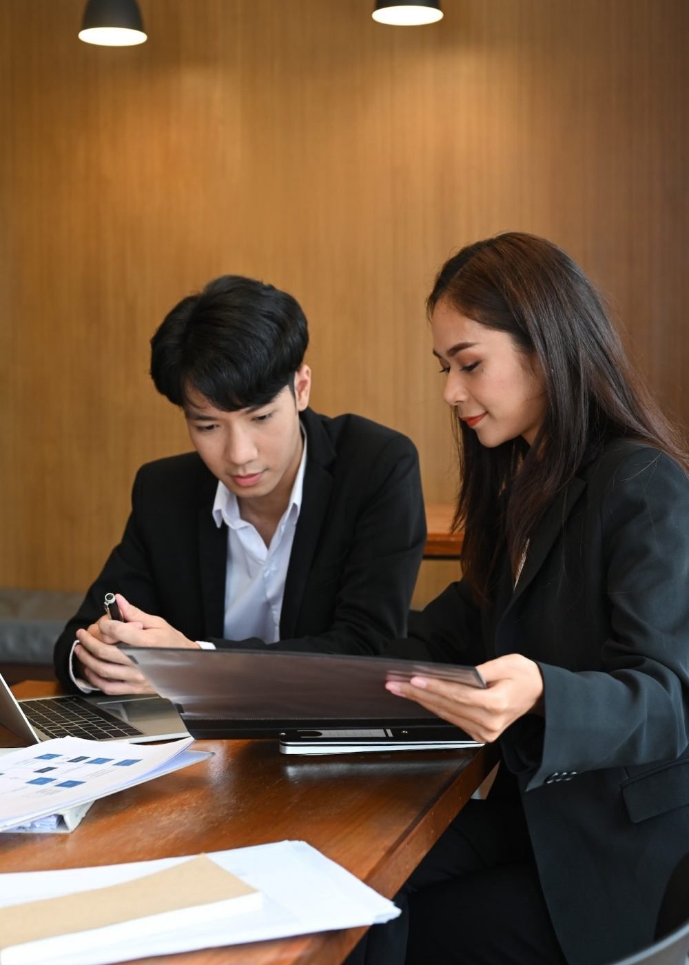 A man and a woman discussing financial reports.